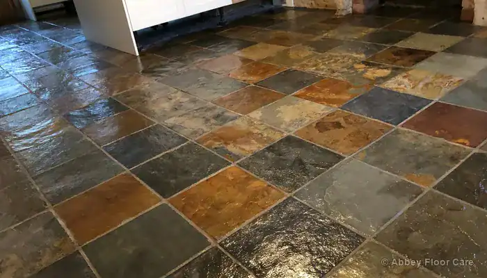 Slate floor with topical gloss sealer adding visible surface sheen